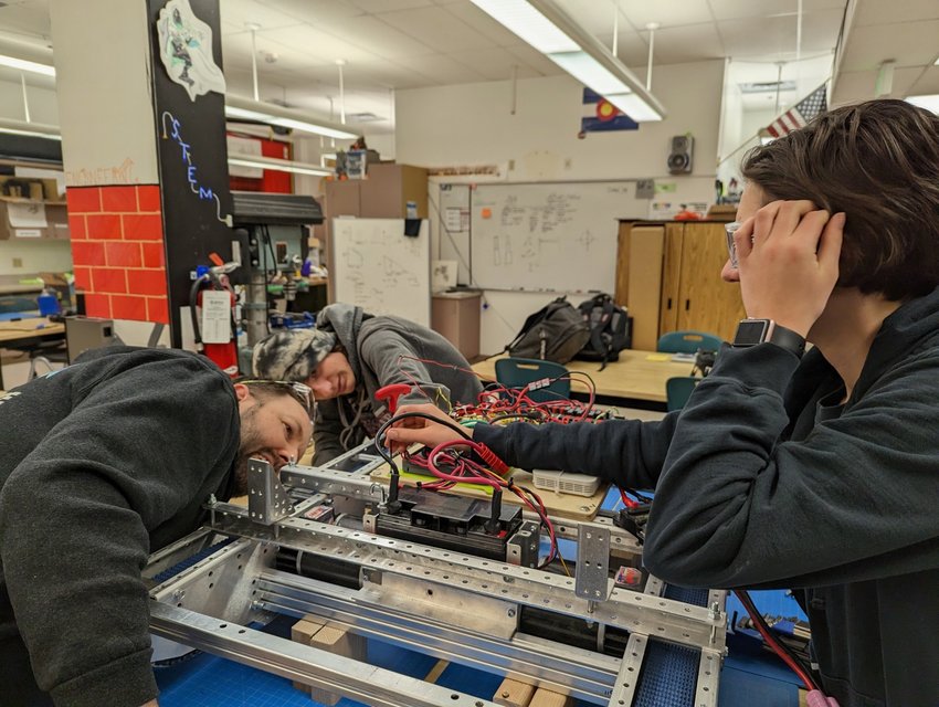 Conifer student Mia Vaughn, mentor Isaac Stauffer and student Johnathan Teklar worked on a practice robot earlier this year that was the basis for the extra robot that Denver East High School’s team could use.